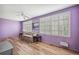 Bedroom with lavender walls, wood-look floors, and white shutters at 2430 Florentine Way # 38, Clearwater, FL 33763