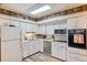 Kitchen with white cabinets, stainless steel appliances, and wood-look floors at 2430 Florentine Way # 38, Clearwater, FL 33763