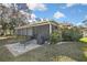 Beautiful backyard featuring a screened porch, brick patio, and lush landscaping at 2603 Royal Ridge Dr, Spring Hill, FL 34606