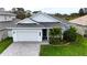 Single-Gathering home with gray roof, white exterior, and landscaped yard at 2993 Breezy Meadows Dr, Clearwater, FL 33760