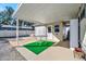 Covered patio with table and chairs, green artificial turf, and storage shed at 322 S Port Royal Ln, Apollo Beach, FL 33572