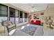 Sunroom with red couch, wicker chair, and colorful rug at 322 S Port Royal Ln, Apollo Beach, FL 33572