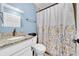 Clean bathroom with granite countertop and floral shower curtain at 3621 19Th Street N, St Petersburg, FL 33713
