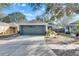One-story house with gray garage door and nicely landscaped yard at 410 Pine Pointe Ct, Seffner, FL 33584