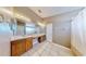 Bathroom featuring a double sink vanity, tiled floors, a large mirror, and a shower/tub combo with curtain at 4317 Knollcrest Ct, Spring Hill, FL 34609