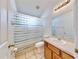 Clean bathroom with a single sink vanity, tiled floors, and a shower/tub combo with curtain at 4317 Knollcrest Ct, Spring Hill, FL 34609
