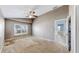 Spacious bedroom featuring carpet floors, light colored walls, a window with blinds, and an entry door at 4317 Knollcrest Ct, Spring Hill, FL 34609