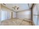 Spacious bedroom with high ceilings, carpet floors, a ceiling fan, a window with blinds, and an entry door at 4317 Knollcrest Ct, Spring Hill, FL 34609