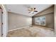 Good-sized bedroom featuring carpet floors, light colored walls, a window with blinds, and an entry door at 4317 Knollcrest Ct, Spring Hill, FL 34609
