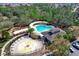 Aerial view of community pool, splash pad, playground, and clubhouse offering recreational opportunities at 4317 Knollcrest Ct, Spring Hill, FL 34609