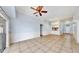 Large living room with tile flooring, ceiling fan, and a view into the kitchen area at 4317 Knollcrest Ct, Spring Hill, FL 34609
