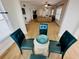Dining area features a glass table and four teal chairs at 4950 Gulf Blvd # 401, St Pete Beach, FL 33706