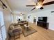 Open living area with hardwood floors, sofas, and a large TV at 4950 Gulf Blvd # 401, St Pete Beach, FL 33706