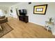 Living room with hardwood floors, a large TV, and tasteful artwork at 4950 Gulf Blvd # 401, St Pete Beach, FL 33706