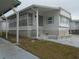 Side view of a white manufactured home with covered walkway and landscaping at 5335 Fairfield S Ave # 78, Gulfport, FL 33707