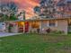 House exterior at dusk showcasing the well-manicured lawn and warm lighting at 6145 55Th N Ave, St Petersburg, FL 33709