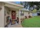 Inviting front porch with red door and rustic wooden benches at 6145 55Th N Ave, St Petersburg, FL 33709