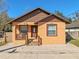 Newly built home with brown and tan exterior, a wooden deck, and a small yard at 806 E Laura St, Plant City, FL 33563