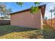 Light brown house side with a wooden fence and grassy yard at 806 E Laura St, Plant City, FL 33563