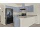 Modern kitchen featuring gray cabinets, granite countertops, and black appliances at 806 E Laura St, Plant City, FL 33563