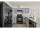 Modern kitchen with granite countertops, gray cabinets, and black appliances at 806 E Laura St, Plant City, FL 33563