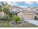 Two-story house with beige exterior, palm trees, and landscaped lawn at 8836 Citrus Palm Dr, Tampa, FL 33626