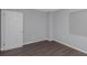 Simple bedroom with gray walls, wood-look floors, and white door at 1202 S Walker St, Plant City, FL 33563