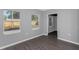 Bedroom with gray walls, wood-look floors, and two windows at 1202 S Walker St, Plant City, FL 33563