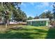 Green house with metal roof, landscaped yard, and walkway at 1202 S Walker St, Plant City, FL 33563