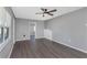 Living room with gray walls, dark floors, and ceiling fan at 1202 S Walker St, Plant City, FL 33563