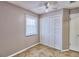 Bedroom with wood-look floors, white closet doors and a window at 13760 Orange Sunset Dr # 201, Tampa, FL 33618