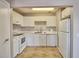 White kitchen with white cabinets, tiled floors and appliances at 13760 Orange Sunset Dr # 201, Tampa, FL 33618