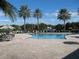 Community pool with palm trees and seating area at 13760 Orange Sunset Dr # 201, Tampa, FL 33618