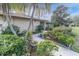 Landscaped walkway leading to a charming single-story home with palm trees at 14022 Passage Way, Seminole, FL 33776