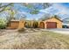 Tan house with red garage door and arched entryway at 1417 Windjammer Loop, Lutz, FL 33559