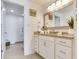 Well-lit bathroom with granite countertop, drawers, mirrors and a green plant at 1520 Gulf Blvd # 1602, Clearwater Beach, FL 33767