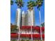Exterior view of a high-rise residential building adorned with vibrant red bougainvillea at 1520 Gulf Blvd # 1602, Clearwater Beach, FL 33767