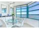 Bright dining room features a glass table, white chairs and stunning water views at 1520 Gulf Blvd # 1602, Clearwater Beach, FL 33767