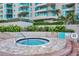 Relaxing hot tub surrounded by lush greenery and brick, offering a private oasis in a condo community at 1520 Gulf Blvd # 1602, Clearwater Beach, FL 33767