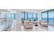 Bright living room featuring expansive windows with ocean views and comfortable seating with bar in the foreground at 1520 Gulf Blvd # 1602, Clearwater Beach, FL 33767