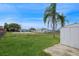 Spacious backyard with a shed, grassy lawn, and a clear view of neighboring homes at 3034 Domino Dr, Holiday, FL 34691