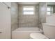 Clean bathroom with gray tile, shower, and white toilet at 3034 Domino Dr, Holiday, FL 34691