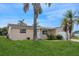 A charming one-story home with a neatly landscaped lawn and palm trees at 3034 Domino Dr, Holiday, FL 34691