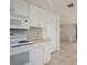 White kitchen with stove, microwave and cabinets at 3034 Domino Dr, Holiday, FL 34691