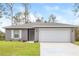Newly constructed home with gray exterior, two-car garage, and well-manicured lawn at 3843 Laslo Ave, North Port, FL 34287