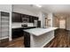 Modern kitchen with dark cabinetry, stainless steel appliances, and breakfast bar at 3843 Laslo Ave, North Port, FL 34287