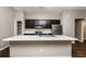Modern kitchen with dark cabinetry, stainless steel appliances, and breakfast bar at 3843 Laslo Ave, North Port, FL 34287