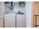 Convenient laundry room with washer, dryer, and storage shelves at 443 Pinellas Bayway S # 105, Tierra Verde, FL 33715