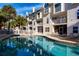 Community pool with surrounding lounge chairs and palm trees at 443 Pinellas Bayway S # 105, Tierra Verde, FL 33715