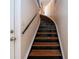 Elegant curved staircase with dark wood and metal railing at 443 Pinellas Bayway S # 105, Tierra Verde, FL 33715